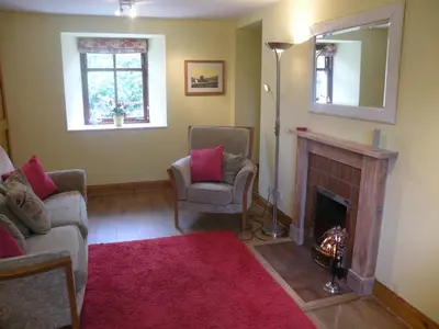 a living room with two chairs and a fireplace at McHugh and Loudon Cottages in Saint Catherines