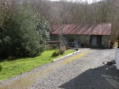 a barn with a rusty roof on a gravel road at McHugh and Loudon Cottages in Saint Catherines