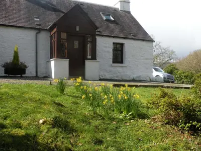 a white house with yellow flowers in front of it at McHugh and Loudon Cottages in Saint Catherines