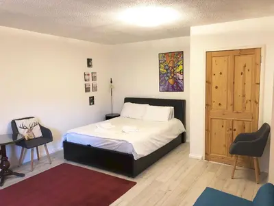 a bedroom with a bed and a table and a door at Castle view&Grassmarket studio flat with Luxury bathroom in Edinburgh