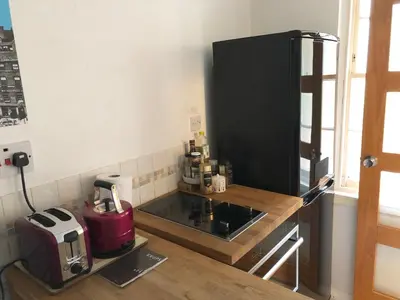 a kitchen with a counter with a coffee maker and a refrigerator at Castle view&Grassmarket studio flat with Luxury bathroom in Edinburgh