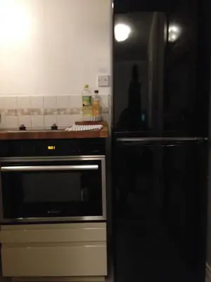 a kitchen with a stove and a black refrigerator at Castle view&Grassmarket studio flat with Luxury bathroom in Edinburgh