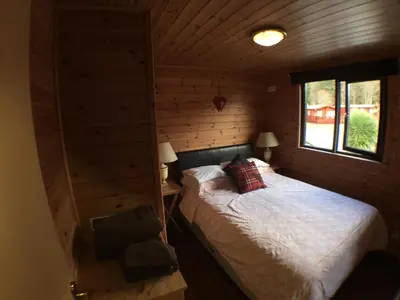 a bedroom with a bed in a log cabin at Lochlomondlodge22 in Rowardennan