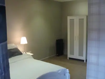 a bedroom with a bed and a lamp and a door at Riggend Farm Accomodation in Airdrie