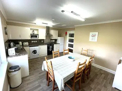 a kitchen and dining room with a table and chairs at Tigh Grianach in Connel