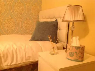 a bedroom with a bed and a lamp on a nightstand at The Guest Wing in Rothesay
