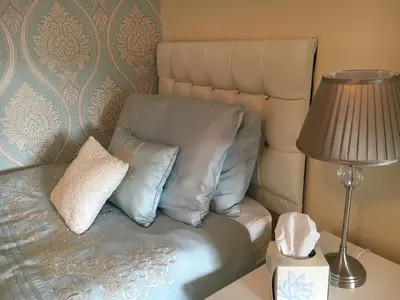 a couch with two pillows on it next to a lamp at The Guest Wing in Rothesay