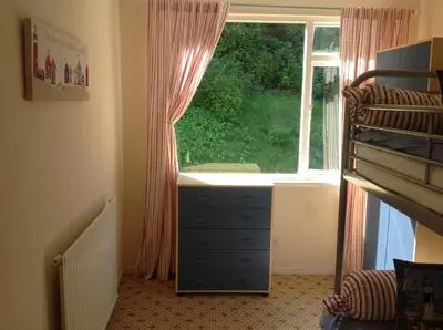 a bedroom with a dresser in front of a window at The Guest Wing in Rothesay