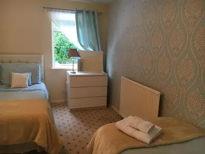 a bedroom with two beds and a window at The Guest Wing in Rothesay
