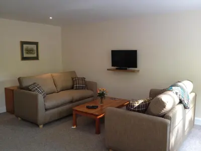 a living room with two couches and a tv at Hearthstanes Steading in Polmood