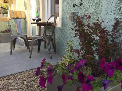 a patio with a table and chairs and purple flowers at Irvine Bay in Irvine