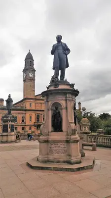 a statue in front of a building with a clock tower at Mycosyapartments54 in Paisley