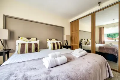 a bedroom with two beds with towels on top of it at No.17 Serviced Apartment in Glasgow
