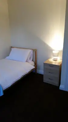 a bedroom with a bed and a nightstand with a lamp at Livingston Ideal commuter House in Livingston