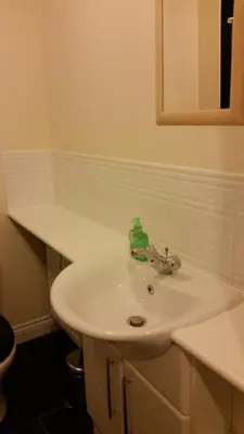 a white bathroom sink with a green bottle on it at Livingston Ideal commuter House in Livingston