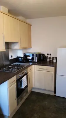 a kitchen with a stove and a white refrigerator at Livingston Ideal commuter House in Livingston