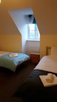 a hotel room with two beds and a window at Livingston Ideal commuter House in Livingston