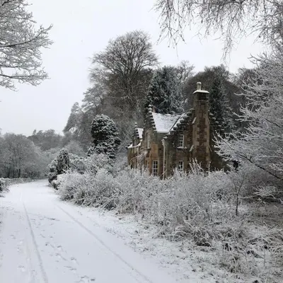 an old house is covered in snow next to a road at Gardener's Cottage in Crieff