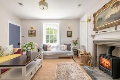 a living room with a fireplace and a couch at Gardener's Cottage in Crieff