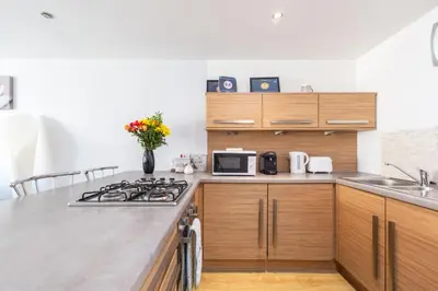 a kitchen with a stove top oven next to a sink at Cosy Apartment in Quiet City-Centre with Car Park in Glasgow