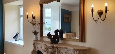a mirror over a fireplace in a living room at Rudha-na-Craige in Inveraray