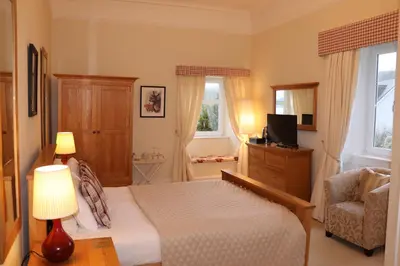 a bedroom with a bed and a television and a chair at Rudha-na-Craige in Inveraray