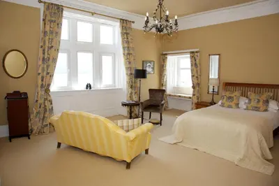 a bedroom with a bed and a chair and windows at Rudha-na-Craige in Inveraray