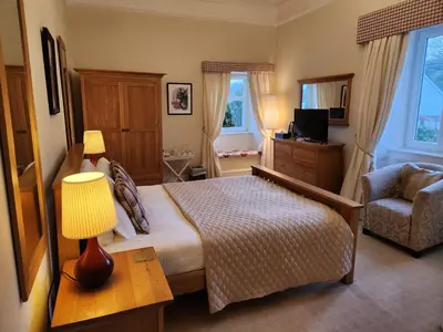 a bedroom with a bed and a lamp and a chair at Rudha-na-Craige in Inveraray