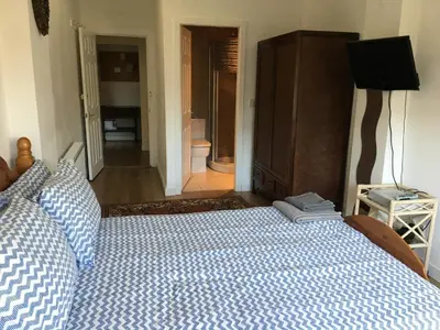 a bedroom with a bed with a blue and white comforter at Charles's Street in Largs