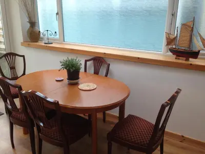 a wooden table and chairs in a room with a window at Charles's Street in Largs
