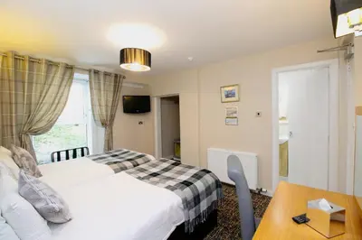 a hotel room with a bed and a table at Kelvingrove Hotel - Sauchiehall St in Glasgow
