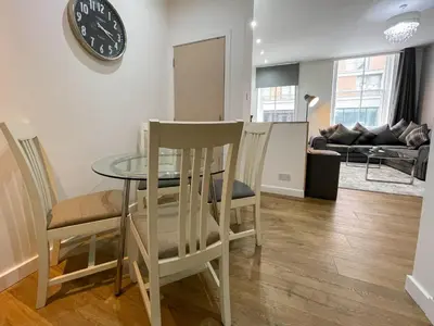 a dining room with a table and chairs and a clock at Exquisite 2BR Flat near Central Train Station in Glasgow