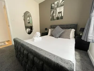 a bedroom with a large bed and two mirrors at Exquisite 2BR Flat near Central Train Station in Glasgow