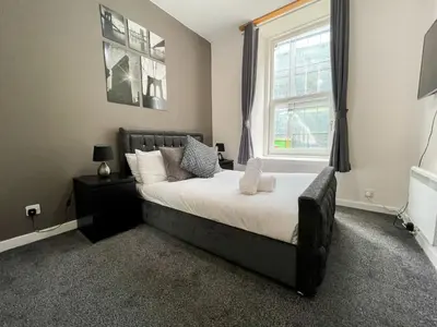a bedroom with a large bed and a window at Exquisite 2BR Flat near Central Train Station in Glasgow