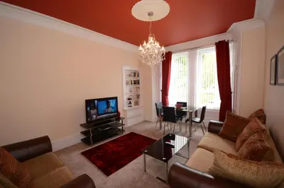 a living room with a couch and a tv at Townhead Apartments Gallery View in Paisley
