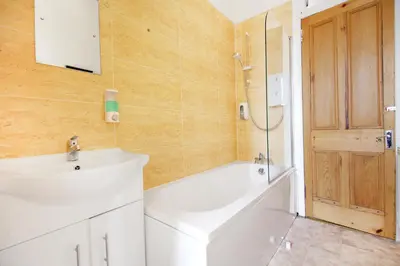 a bathroom with a sink and a tub and a shower at Townhead Apartments Gallery View in Paisley