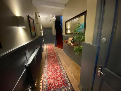 a hallway with a red rug next to a door at Irvine Guest House in Irvine