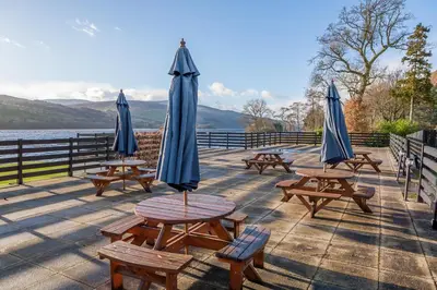 a group of picnic tables with umbrellas on a deck at The Kenmore Club in Kenmore
