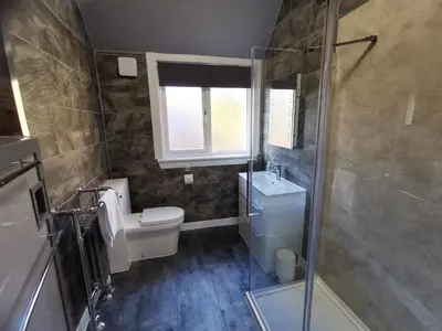 a bathroom with a toilet and a sink and a shower at The Knowe Guest House in Callander