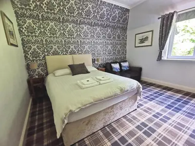 a bedroom with a large bed in a room at The Knowe Guest House in Callander