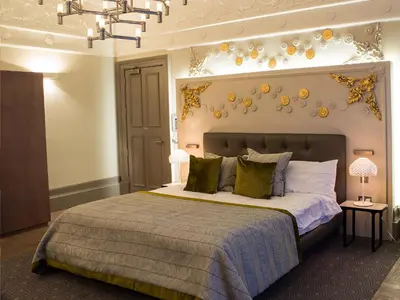 a bedroom with a large bed and a chandelier at Lynnhurst Hotel in Johnstone