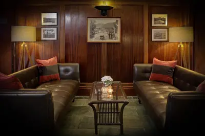 a living room with two leather couches and a table at BEST WESTERN The Crianlarich Hotel in Crianlarich