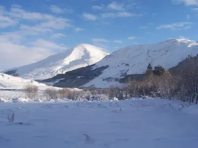 a snow covered mountain in front of a snow covered field at BEST WESTERN The Crianlarich Hotel in Crianlarich