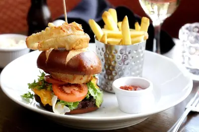 a plate with a sandwich and french fries on a table at BEST WESTERN The Crianlarich Hotel in Crianlarich