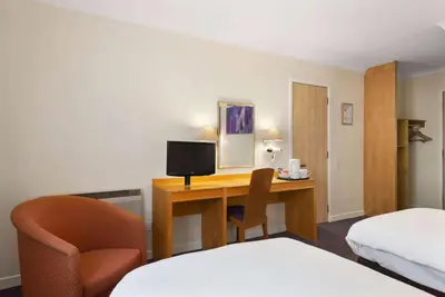 a hotel room with a desk with a computer and a bed at Days Inn Hamilton in Hamilton