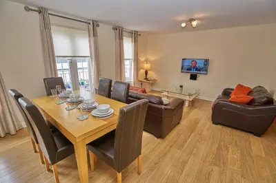 a living room with a dining table and a couch at Edinburgh Pearl Apartments - Haymarket Residence in Edinburgh