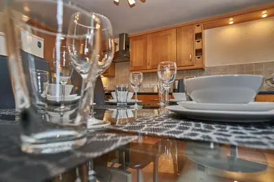 a kitchen with a table with glasses on it at Edinburgh Pearl Apartments - Haymarket Residence in Edinburgh