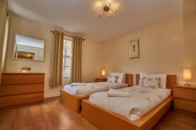 a bedroom with two beds and a window at Edinburgh Pearl Apartments - Haymarket Residence in Edinburgh
