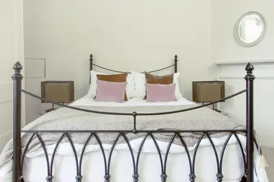 a bedroom with a black and white bed with pink pillows at Ramsay Gardens - Grand 4-Bedroom Apartment Next To Castle in Edinburgh