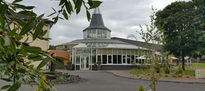 a large building with a tower on top of it at Alona Hotel in Motherwell